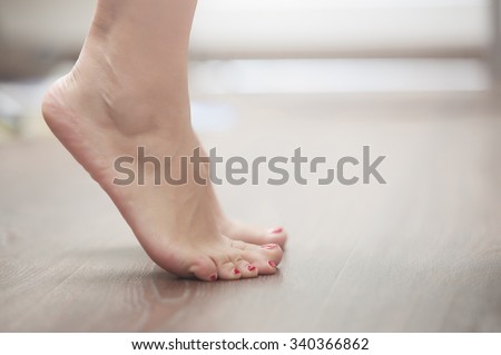 Feet of woman standing on tiptoe at home