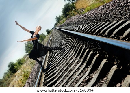 Ballet dancer on the railway in dynamic pose