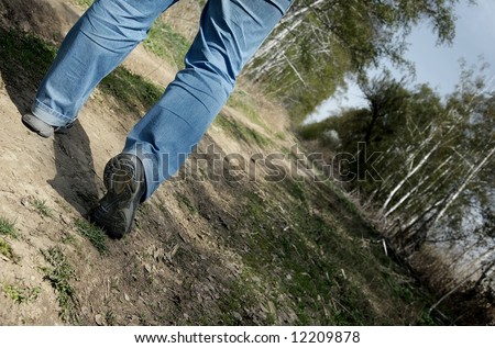 Close-up photo of the man legs walking through the forest