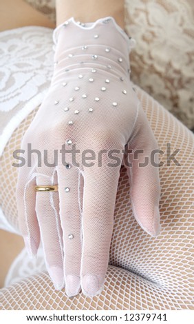 Close-up photo of the elegant hand in glove with wedding ring
