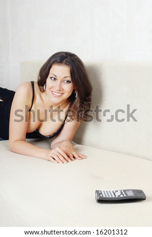 Portrait of the cheerful lady waiting for a call and looking at the telephone