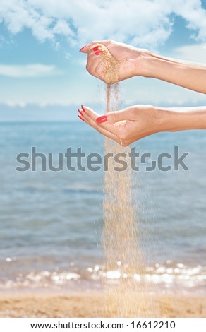 Close-up photo of the woman hands playing with sand