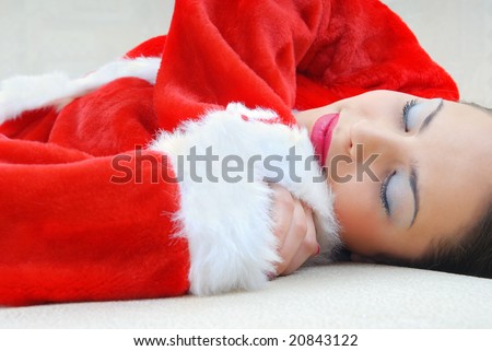 Sleeping pretty woman in the red costume of Santa Claus
