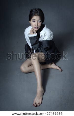 Sad Asian lady sitting with shoeless legs