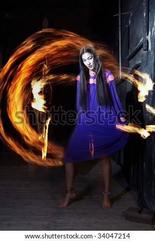 Fire rings behind the gorgeous Asian witch