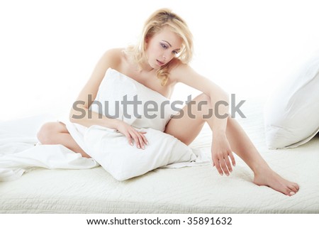 Sexy naked lady on the bed covered by the pillow