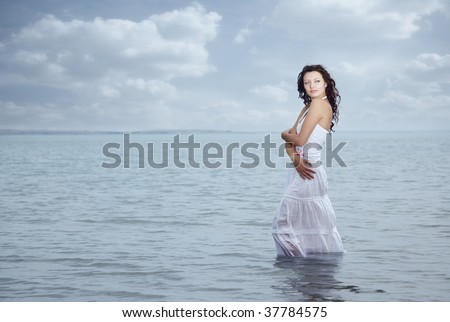 Woman with wet skirt standing in the water