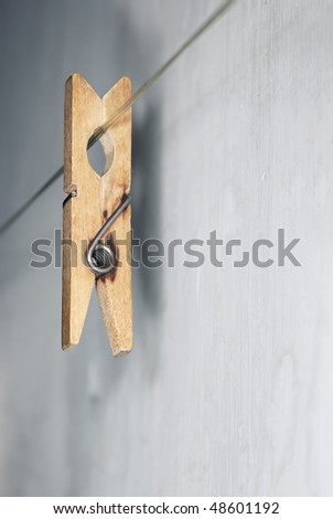Close-up vertical photo of the old wooden clothes pin hanged on a clothes-line