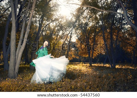 stock photo Lady in the wedding dress dancing in the autumn golden forest