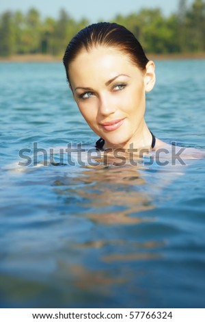 Beautiful lady in the water. Vertical close-up portrait. Artistic colors added