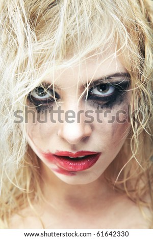 Blond lady with bizarre makeup and smeared lipstick on her face. Close-up photo. Natural colors