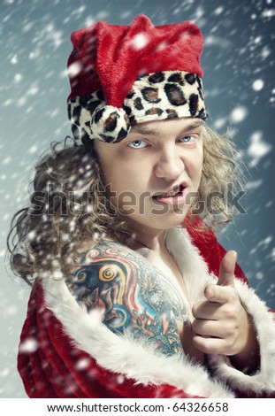 stock photo : Bad man with colored tattoo in the red Santa Claus costume