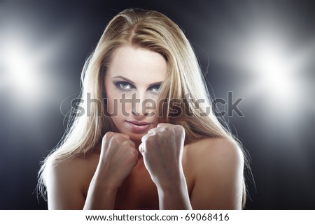 Horizontal photo of the blond female fighter in the studio with flash backlight