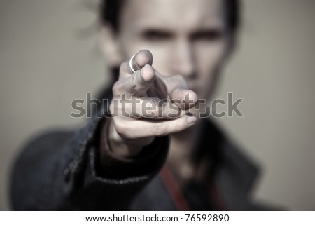 Close-up photo of the criminal man pointing finger. Focus on the fingertip