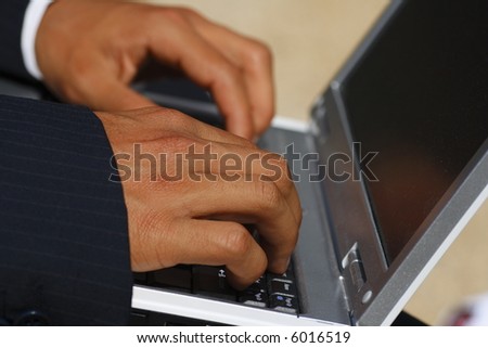 Someone typing work on the computer laptop to signify mobile computing.