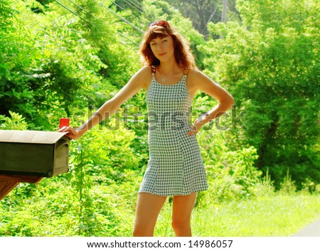 Pretty girl checking mail box for mail.
