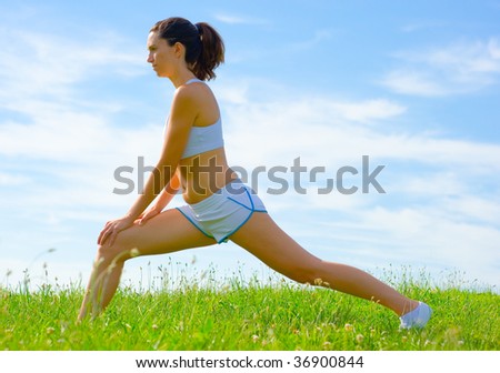 Mature woman athlete practicing in a spring meadow, from a complete series.