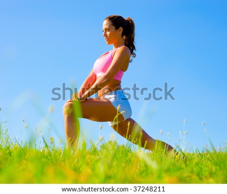 Athletic woman working out in a meadow, from a complete series of photos.