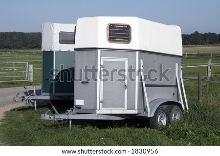 silver horse trailer on green weadow
