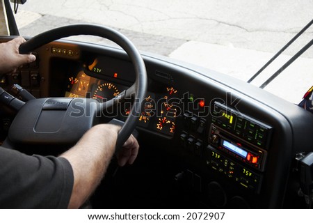 dashboard of a bus with the arms of the bus driver