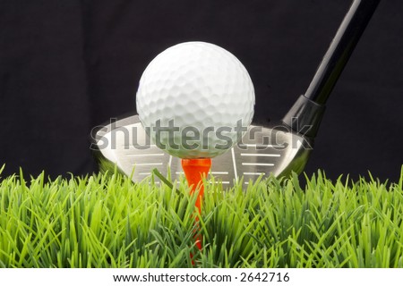 white golfball on tee, driver behind, isolated on black background