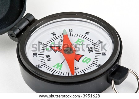 Compass with white face, red needle, black case on white background