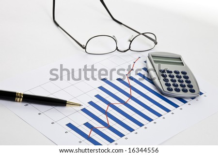 Bar chart on white paper with glasses and pen