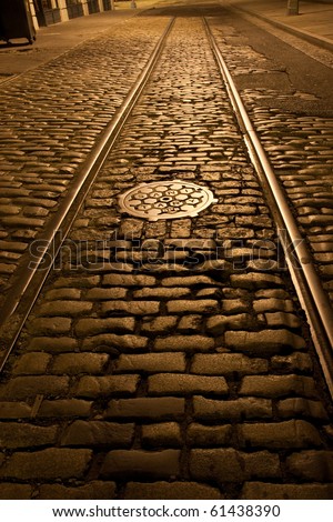 Old trolley tracks and cobblestones survive under the flaking asphalt pavement of this Brooklyn Heights street, Brooklyn, New York. A night time exposure.