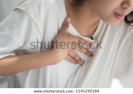 sick woman with indigestion problem, acid reflux or gerd symptoms; woman health care, body care, sickness, pain, acid reflux concept; asian middle east 20s adult, mixed race woman model