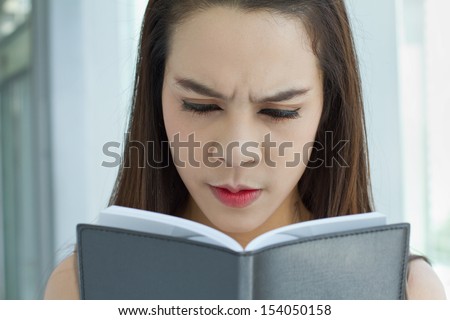 woman looking at notebook with stress, negative emotion
