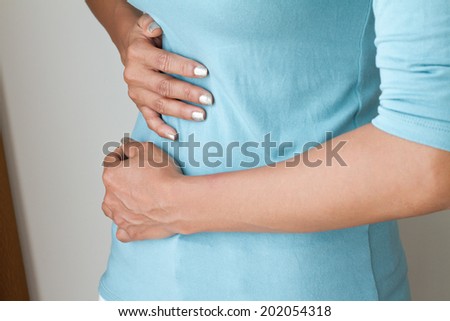 menstruation pain or stomach ache, hand holding belly closeup