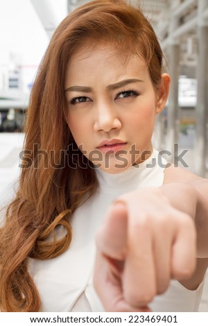 serious woman pointing finger at you
