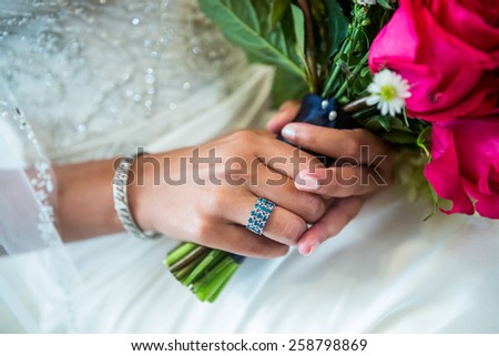 Beautiful closeup of an ethnic brides\'s blue and silver ring on the hands of a beautiful ethnic bride.