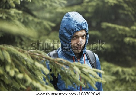 Young man in forest in rain - selective focus