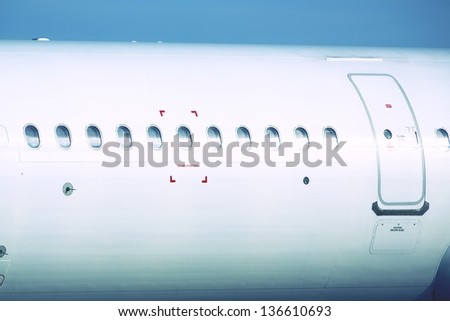 Windows of the white airplane with emergency sign.