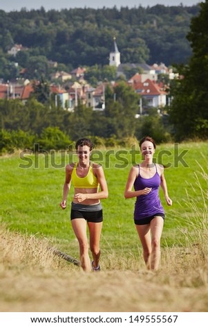 Two girls are running in nature - selective focus