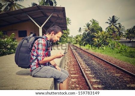 Young Traveler With Mobil Phone In The Railway