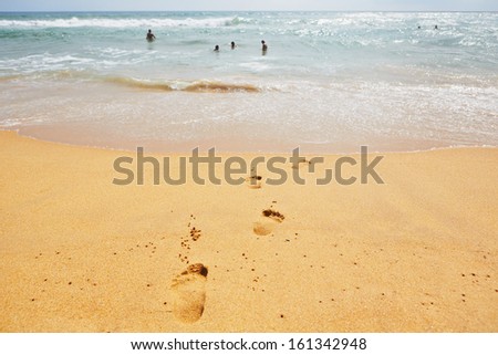 Human footprint in wet sand on the beach - selective focus