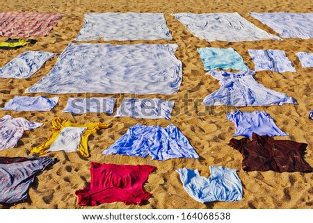 Washed clothes are drying on the beach.