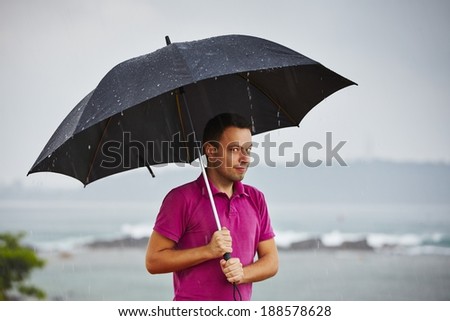 Man with black umbrella in heavy rain