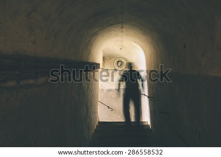 Man is walking through dark underground