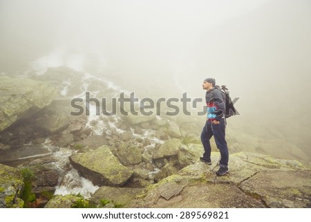 Traveler in thick fog in the mountains.