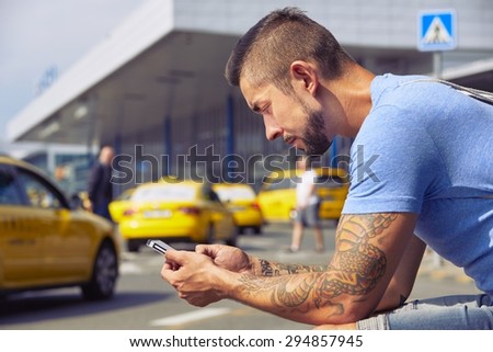 Man is ordering taxi, using mobile phone app