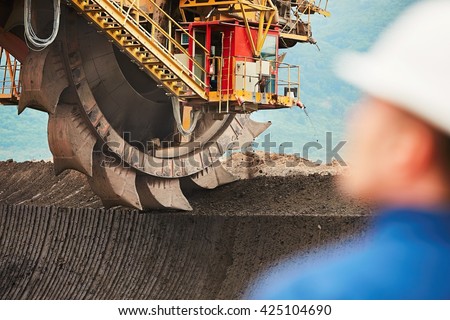 Coal mining in an open pit - Worker is looking on the huge excavator - industry in Czech Republic