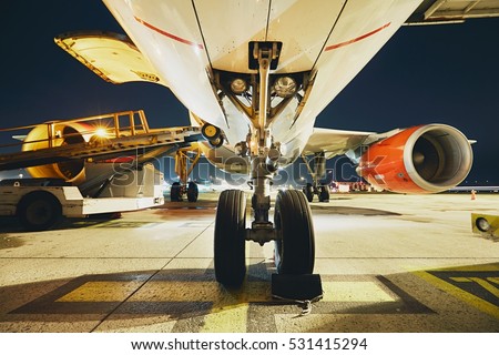 Busy airport in the night. Preparation of the airplane before flight.