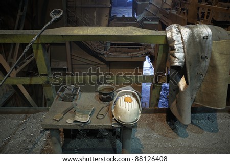 Work tools, protective helmet and coat in steel mill.