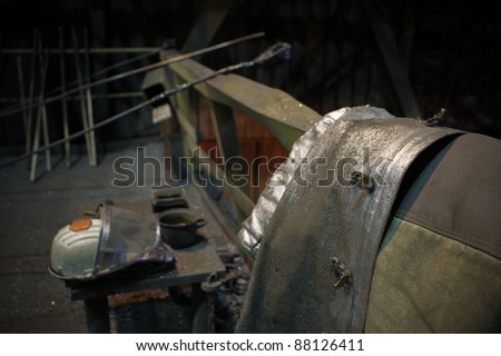 Work tools, protective helmet and coat in steel mill - focus on the coat