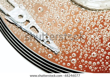 Open hard drive disk with water drops. Concept of condensation. Macro focused on magnetic head.