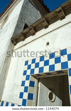 An old abandoned building showing the open door to the ladies room....with \