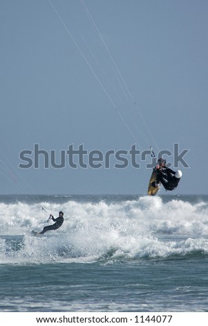 Kite surfers ( kite boardesr ) riding and jumping the waves near Cayucos, California.